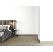 Slaapkamer met bed, nachtkastje en staande lamp