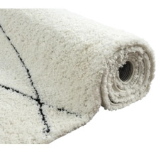 Opgerolde, witte vloerkleed met zwart patroon