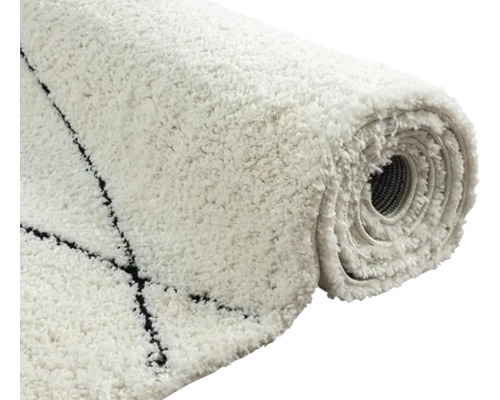 Opgerolde, witte vloerkleed met zwart patroon