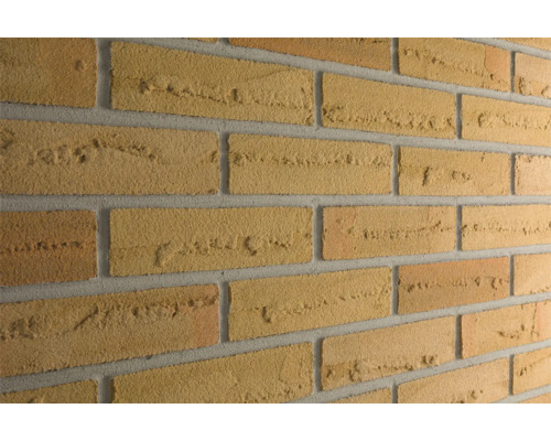 Close-up van een bakstenen muur met rechthoekige bakstenen en mortelvoegen.