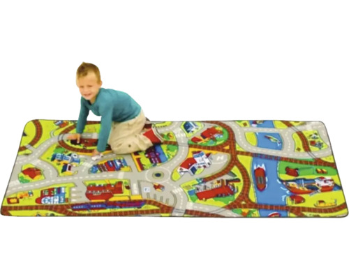 Kind speelt op een speelkleed met straten- en spoorwegmotieven.