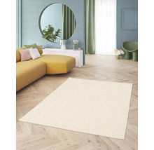 Beige hoogpolig tapijt in een woonkamer met een gele bank en een ronde spiegel.