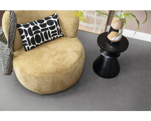Scene met fauteuil, kussen, bijzettafel en decoratie voor een gezellige sfeer in de kamer