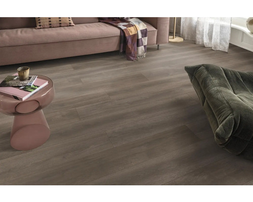 Woonkamer met laminaatvloer in houtlook, bank en fauteuil