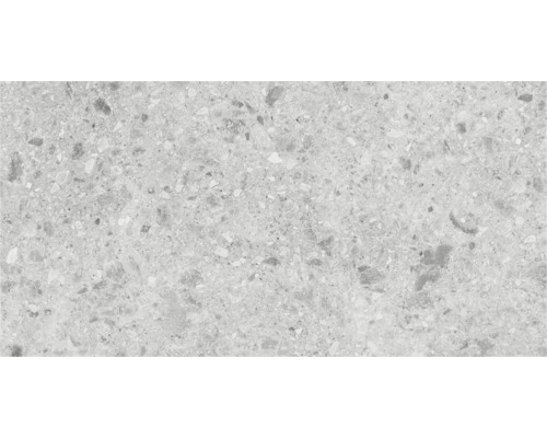Close-up van een vloertegel met terrazzo-look.