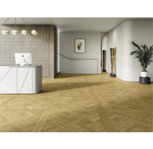 Moderne ontvangstruimte met gedessineerde vloertegels in parketlook, balie en minimalistische inrichting.