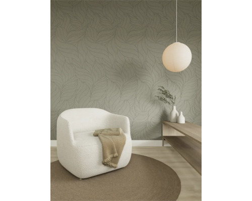 Moderne woonkamer met behang met bladpatroon, een fauteuil van gestructureerde stof, een rond tapijt en een houten plank.