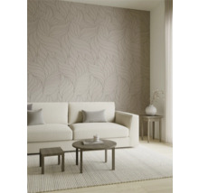 Lichte woonkamer met behang met bladmotieven in neutrale tinten, een crèmekleurige bank en moderne houten tafels.