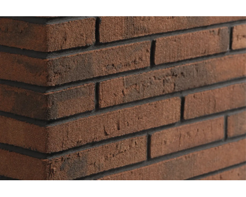 Close-up van een gemetselde muur van gestructureerde bakstenen met donkere voegen in verband