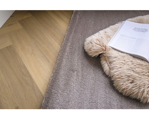 Tapijt op houten vloer met boek en kussen