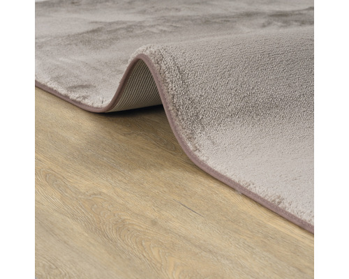 Detailweergave van een grijs tapijt op een houten vloer