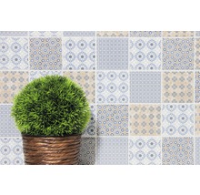 Decoratieve muur met patchwork tegels en plant in mand