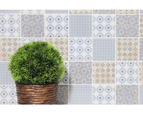 Decoratieve muur met patchwork tegels en plant in mand