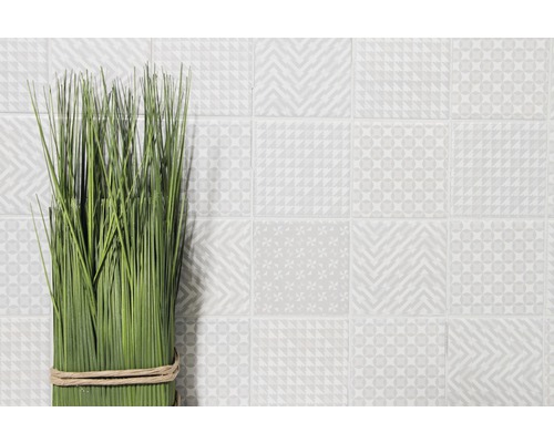 Decoratieve groene grassen met licht gemusterde tegels op de achtergrond.