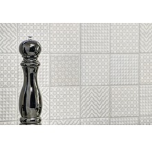 Wanddecoratie met verschillende decoratieve tegels en pepermolen
