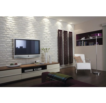 Woonkamer met televisie, planken, fauteuil, vloerlamp en houten vloer