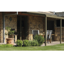 Terras met tuinmeubelen, barbecue en stenen muur
