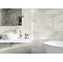Badkamer met wastafel, bad en wandtegels in marmerlook