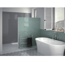 Badkamer met bad, betegelde wand en handdoekradiator
