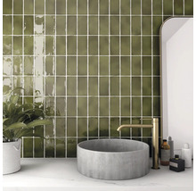 Badkamer met wandtegels, wastafel en kraan