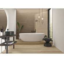 Lichte badkamer met ligbad, wastafel, spiegel en wandtegels met houtlook