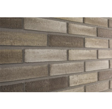 Close-up van een bakstenen muur met lichte en donkere bakstenen.