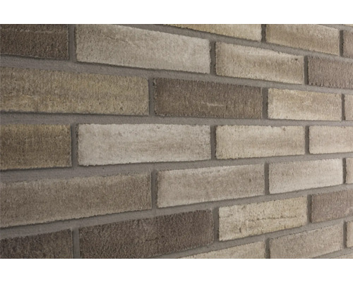 Close-up van een bakstenen muur met lichte en donkere bakstenen.