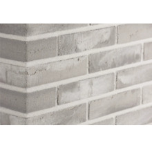Close-up van een grijze bakstenen muur met lichte mortel