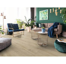 Lichte woonkamer met laminaatvloer, bank en fauteuil