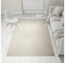 Beige tapijt in een lichte woonkamer met bank en stoel