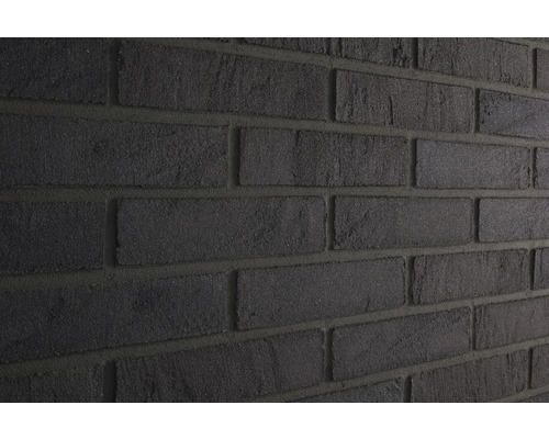Close-up van een muur met donkere gevelstenen