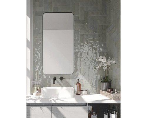 Badkamer met wastafel, spiegel, kraan en wandtegels