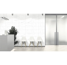 Lichte ruimte met witte wandtegels, receptie, stoelen en plant.