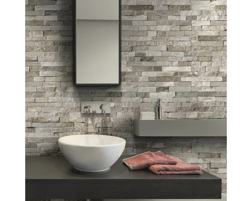 Badkamer met wastafel, spiegel en wandbekleding in steenlook