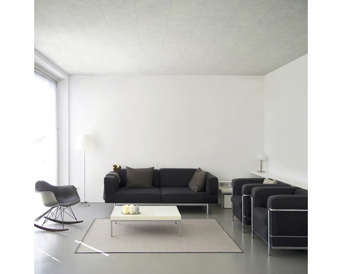 Lichte woonkamer met zwarte bank, fauteuils, witte salontafel en vloerkleed.