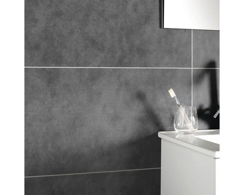 Detailopname van een badkamer met grijze tegels en een wastafel met tandenborstel